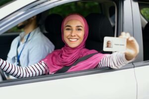 Joyful Islamic Lady In Hijab Demonstrating Driver Licence At Camera